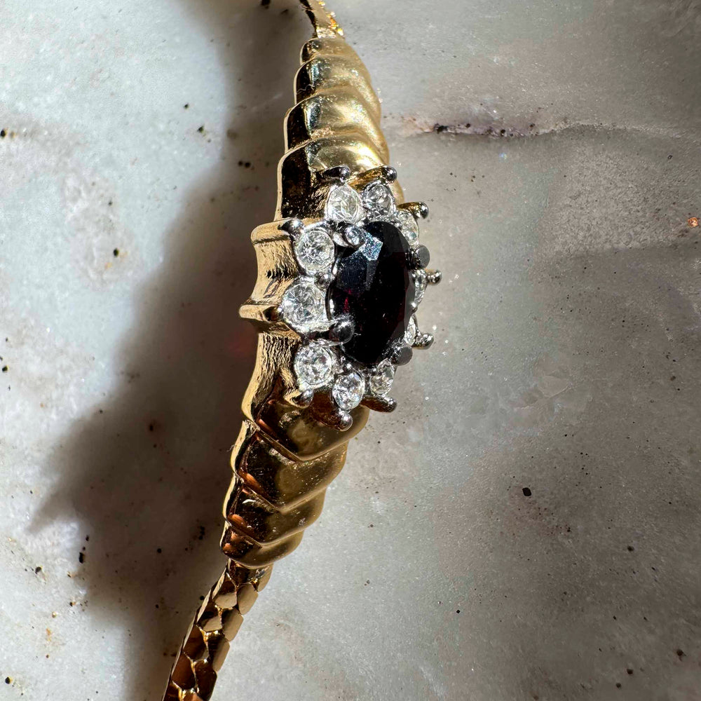 
                      
                        Vintage Gold-Tone Bracelet with Deep Red Centerpiece
                      
                    